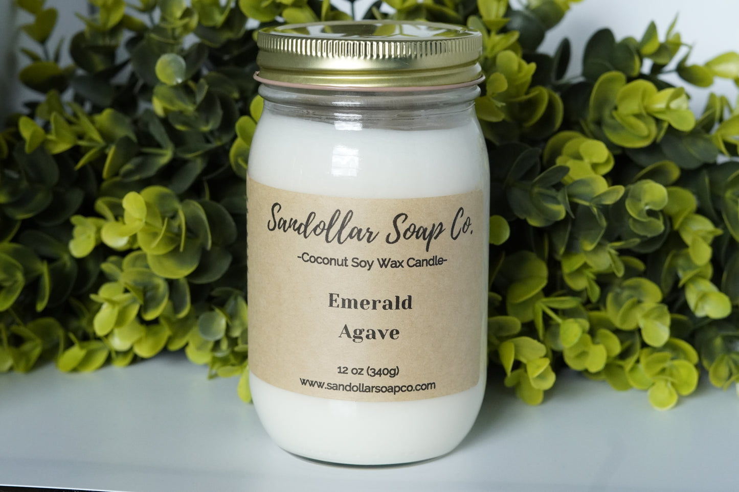 A 12 oz coconut soy wax candle in a mason jar that includes a gold lid. Made with a cotton wick and scented "Emerald Agave." A best seller! This is a tantalizing & fruity blend of sea moss, melon, agave, passionflower, acai, aloe, coconut bark, teakwood, grass, and amber.