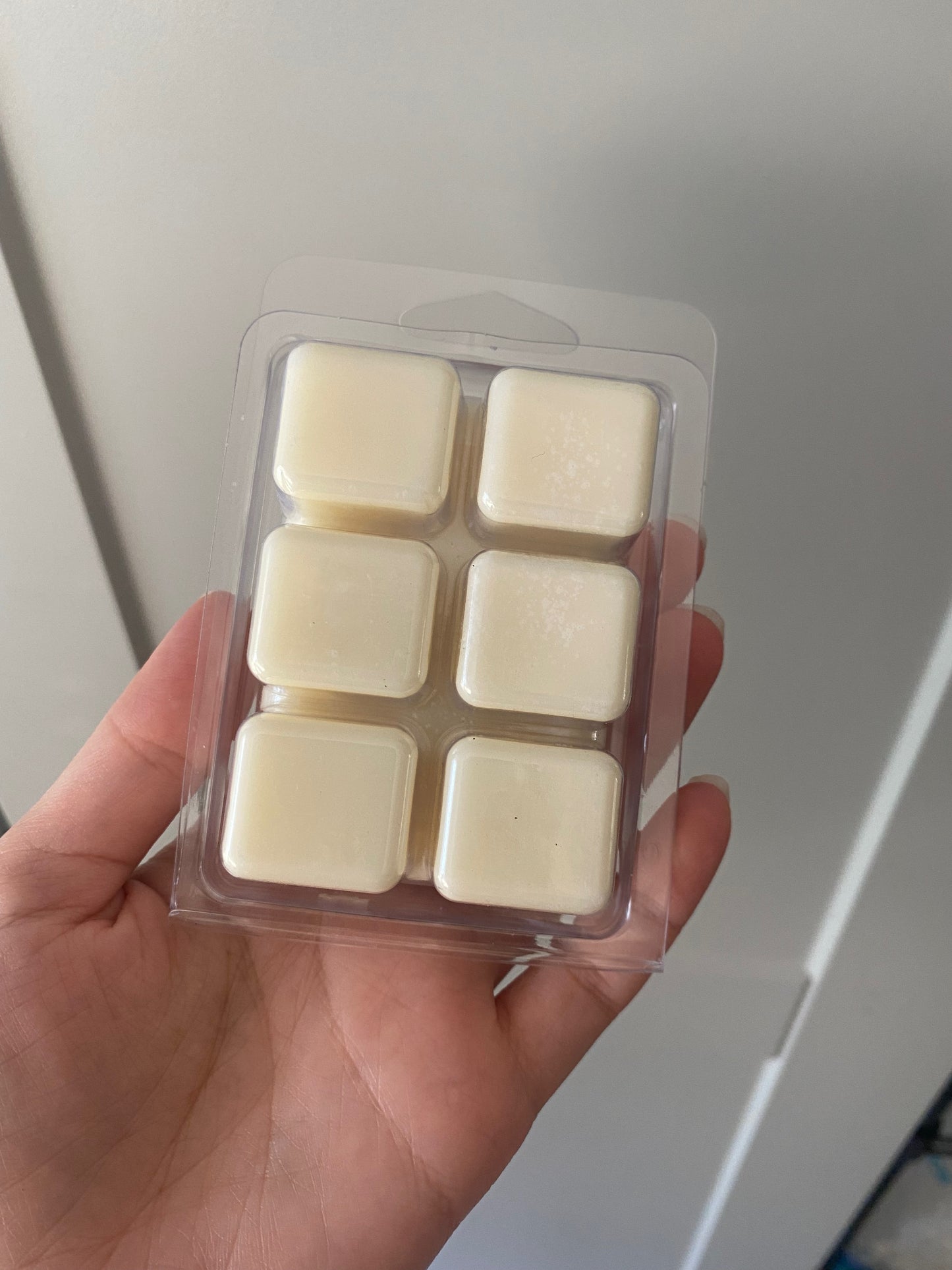 The bottom of a plastic container with six squares containing soy wax
