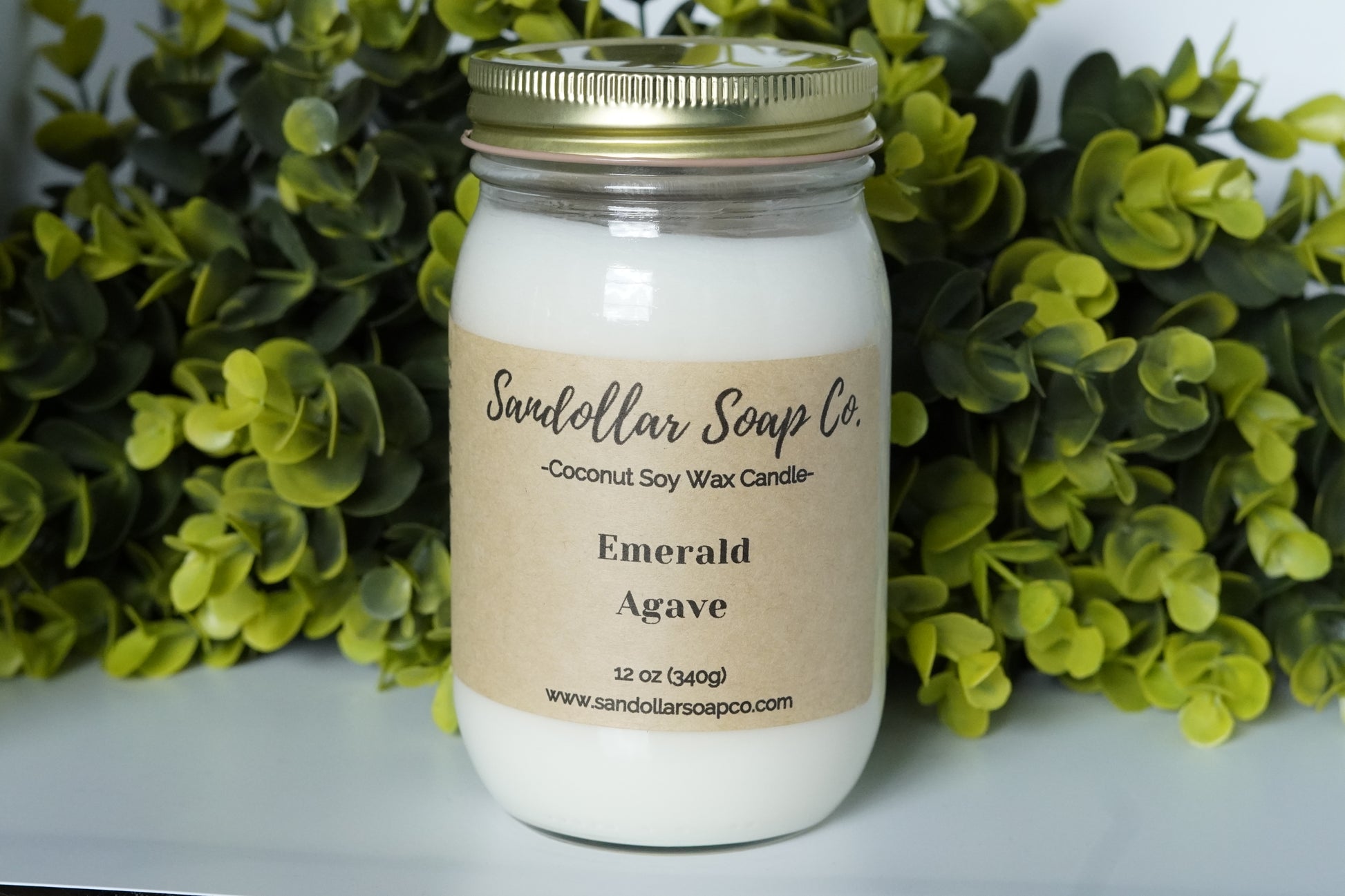 A 12 oz coconut soy wax candle in a mason jar that includes a gold lid. Made with a cotton wick and scented "Emerald Agave." A best seller! This is a tantalizing & fruity blend of sea moss, melon, agave, passionflower, acai, aloe, coconut bark, teakwood, grass, and amber.