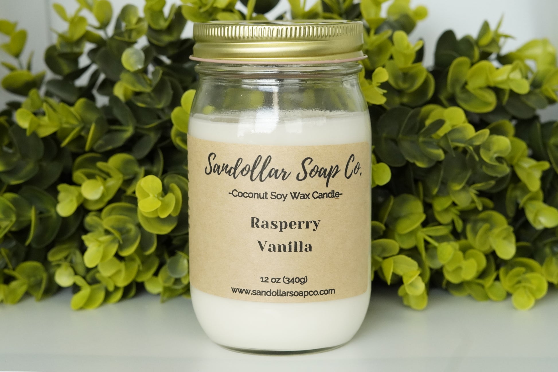 A 12 oz coconut soy wax candle in a mason jar that includes a gold lid. Made with a cotton wick and scented "Raspberry Vanilla." Light and sweet blend of bergamot, pear, plum wine, vanilla, orchid, cashmere, and musk.