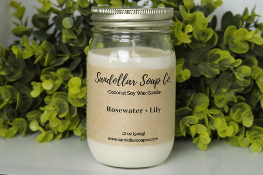 A 12 oz coconut soy wax candle in a mason jar that includes a gold lid. Made with a cotton wick and scented "Rosewater and Lily." Soft rose and lily balanced with notes of amber and cedar.