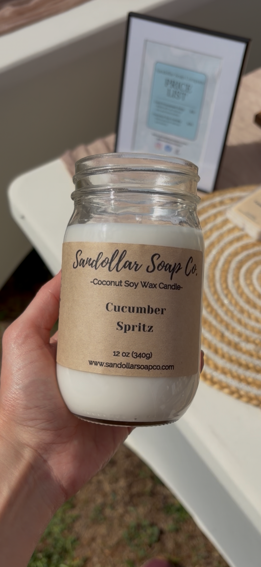 Hand holding a jar of 'Cucumber Spritz' soap