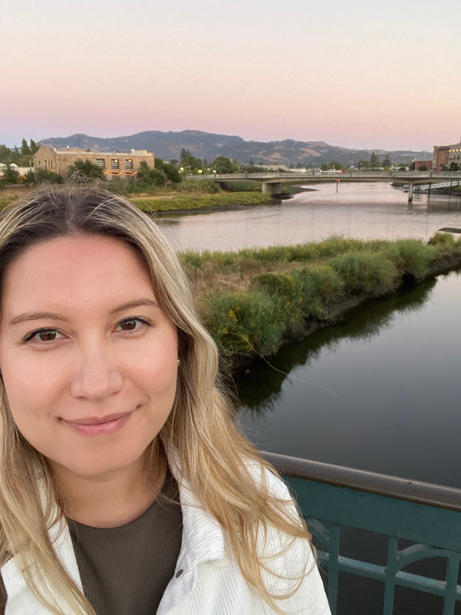picture of a girl in front of a river and mountain
