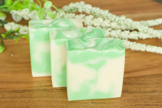 green and white soaps in front of foral greenery